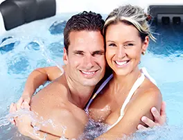 Happy couple enjoying a portable spa in their backyard hot tub