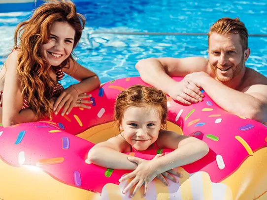 Family enjoying inflatable hot tub floats in backyard swimming pool together