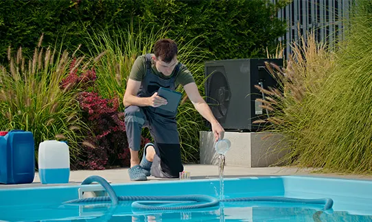 Man testing water chemistry for residential spa and backyard pool maintenance