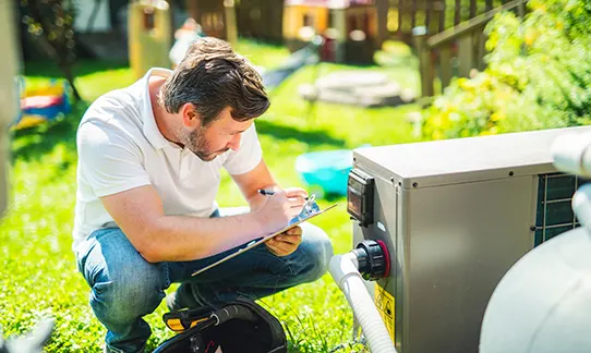 Man performing hot tub maintenance on residential spa in backyard garden