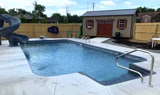 Modern backyard pool with adjacent spa featuring residential pool ownership setup and maintenance area