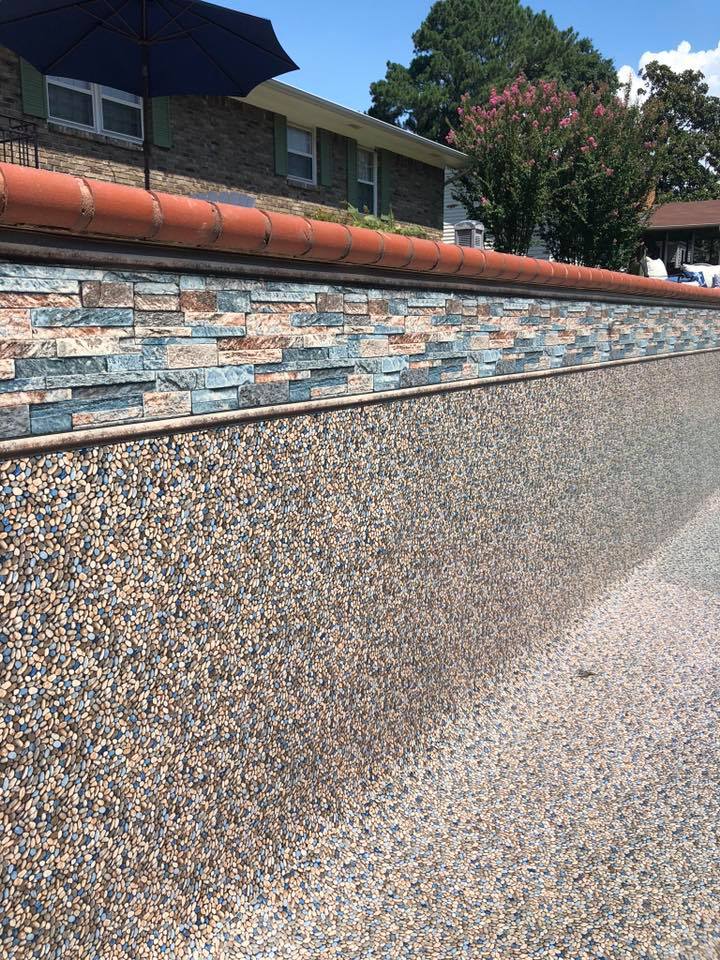 Residential backyard retaining wall with decorative stone and copper coping detail