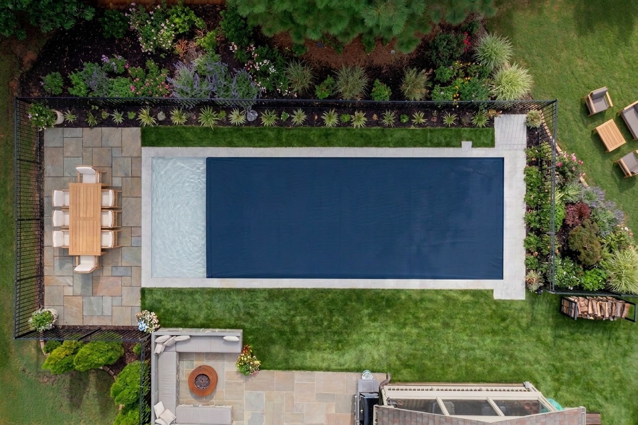 Aerial view of modern backyard with rectangular swimming pool and dining patio area