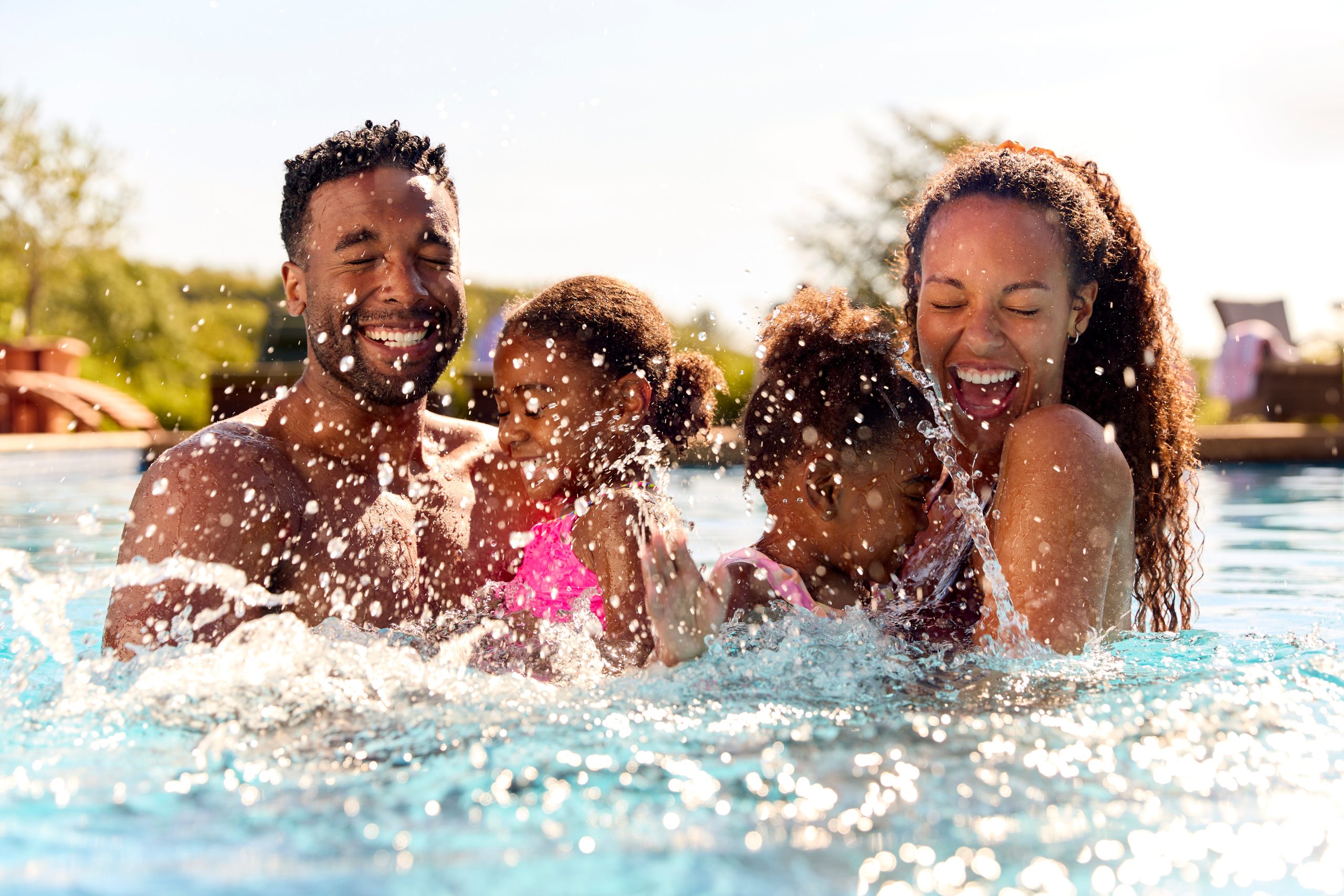 Family enjoying summer fun together in a residential backyard pool