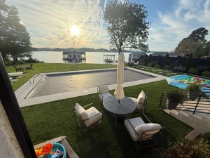 Luxurious backyard with in-ground pool, hot tub, and comfortable lounge seating overlooking waterfront