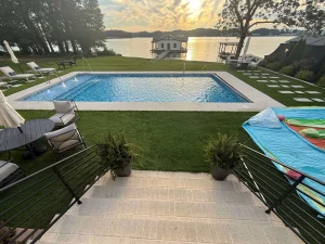 Luxury backyard pool with lounge chairs and waterfront views at residential spa property
