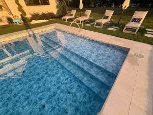 Luxurious backyard pool with integrated spa features and lounge seating area