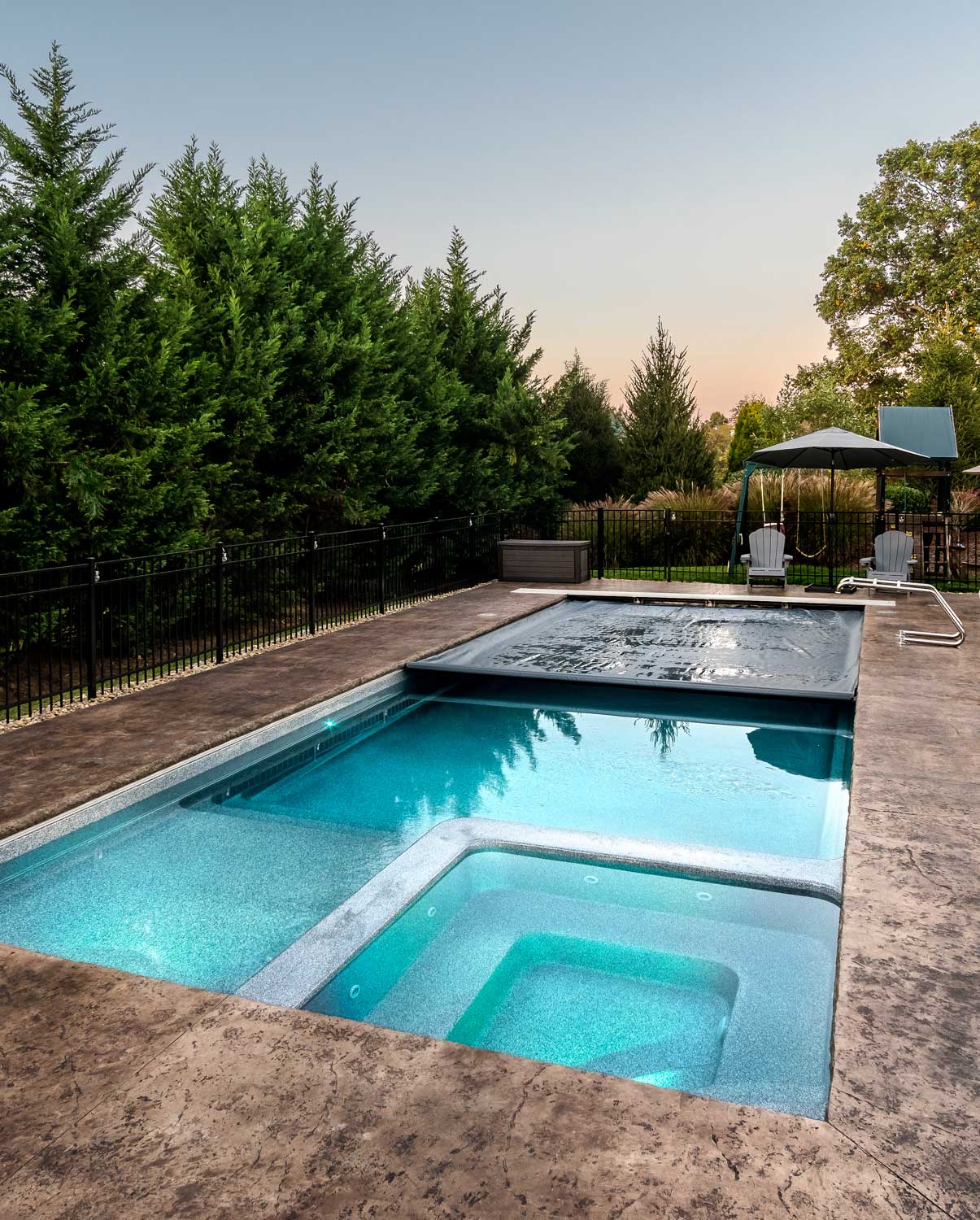 Luxurious backyard pool and hot tub with spa cover in residential outdoor setting
